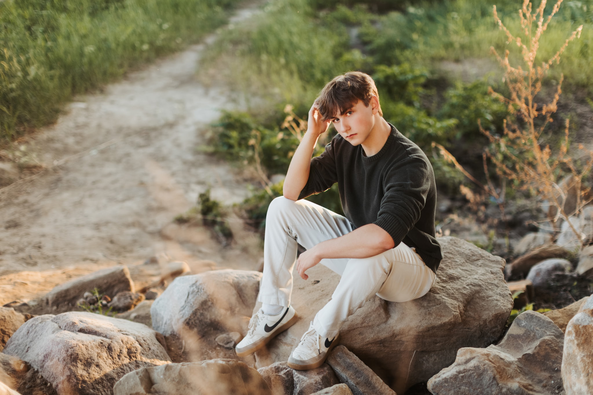 Griffin seated outdoors on rocks beside a path